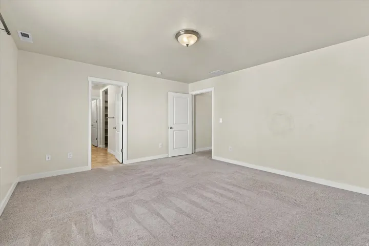 Plush carpet flooring, neutral wall tones, white trim, and a semi-flush mount ceiling light