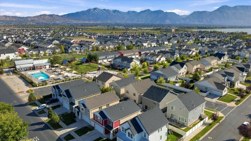 Expansive residential development featuring a community pool, recreational green space, and mountain backdrop