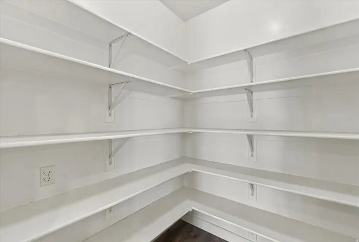 White built-in shelving, abundant storage, and wood-finish flooring