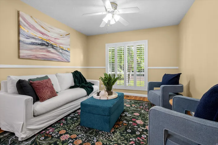 Vaulted ceiling with a ceiling fan, crown molding, chair rail molding, and plantation shutters