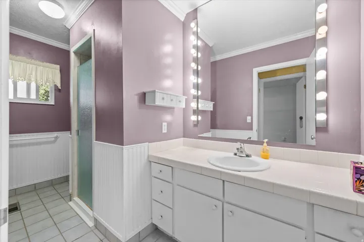 Vanity with integrated sink, integrated wall mirror, and surrounding vanity lighting