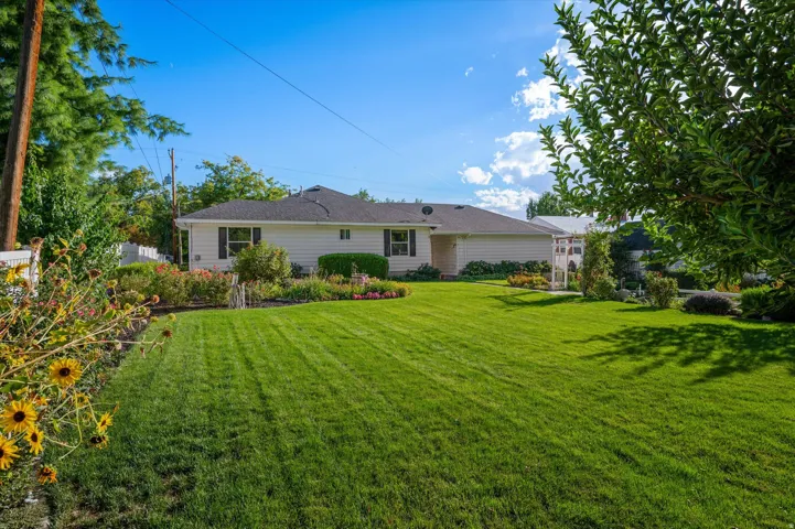 Expansive front lawn with mature trees and established landscaping