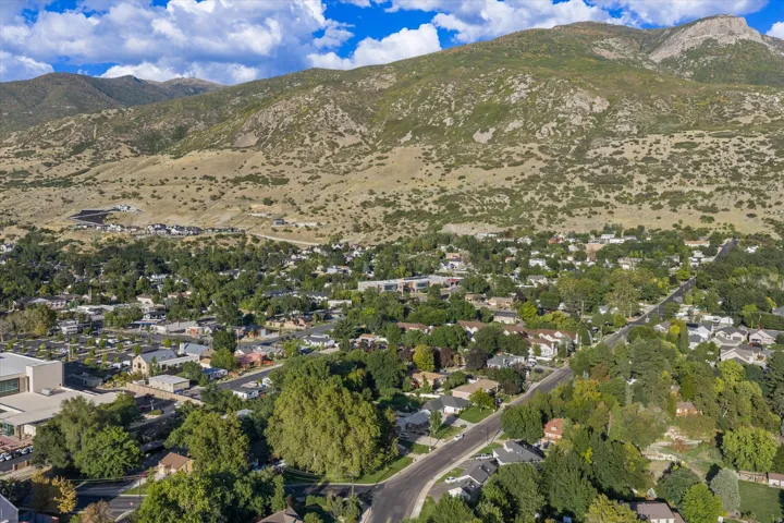 Residential area with varied architectural styles, mature trees, and mountainous terrain