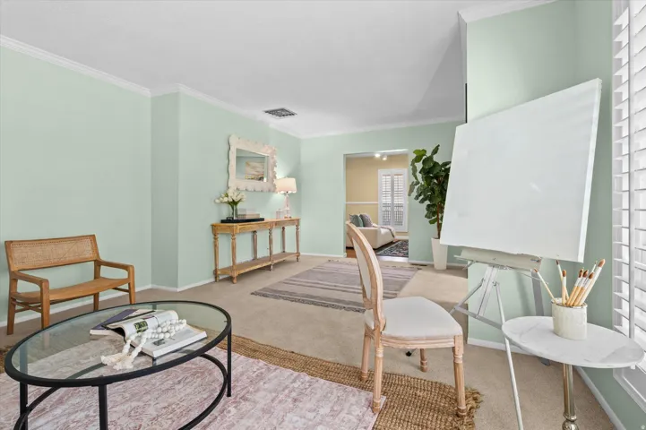 Carpeted flooring, crown molding, and plantation shutters