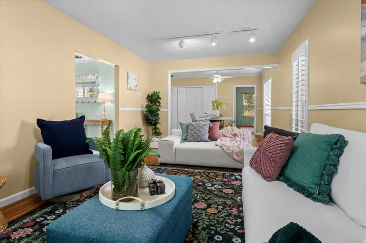 Wood-finish flooring, plantation shutters, and track lighting fixtures contribute to the interior aesthetic