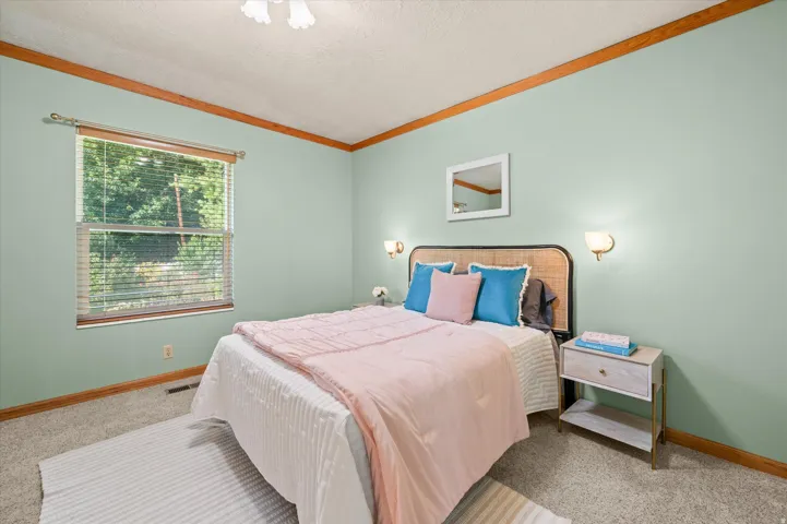 Wall-mounted sconce lighting, wood trim details, and a window with blinds
