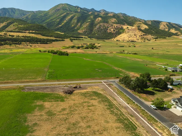 Expansive undeveloped land with a paved road and mountain backdrop