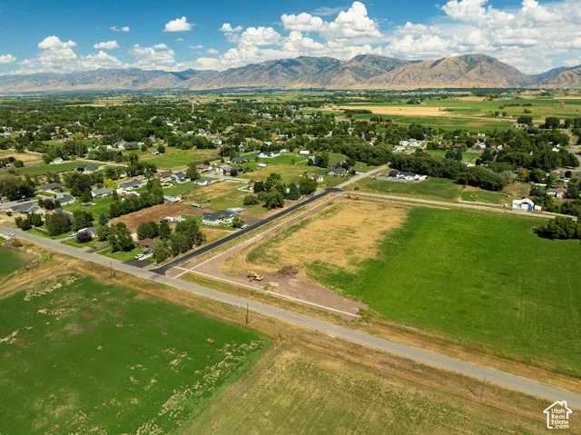 Expansive agricultural land with surrounding residential areas and distant mountains
