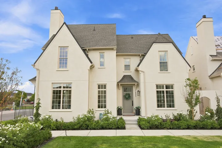 Stucco exterior with multiple gables, covered entry, and a well-defined walkway