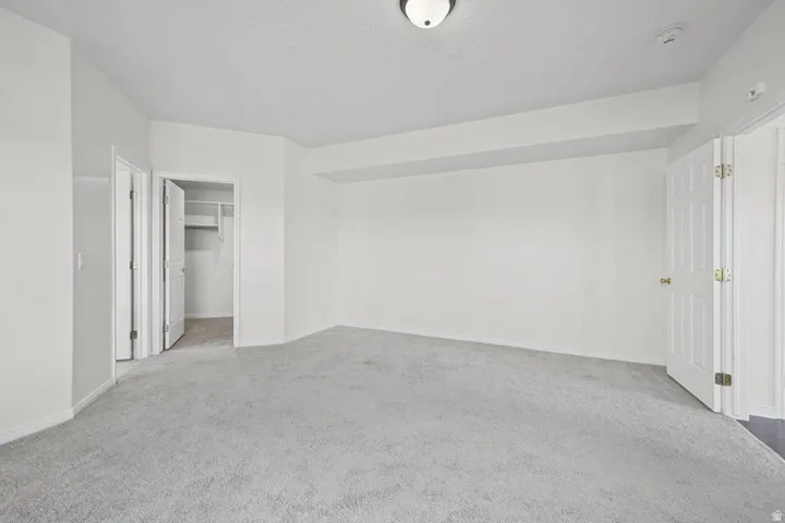 Neutral tone wall paint, light-colored carpeting, white trim, and a white interior door