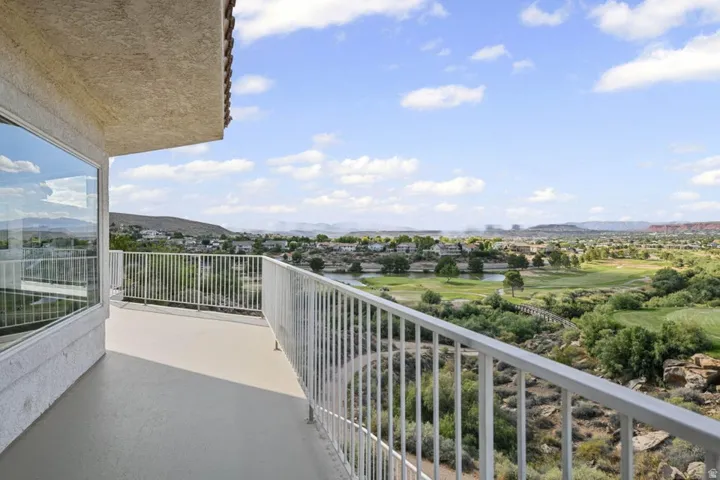 Expansive outdoor balcony with white railings and stucco exterior