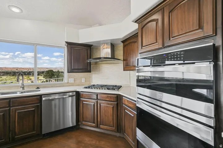 Kitchen featuring wood cabinetry, stainless steel appliances, a gas cooktop, and a tile backsplash