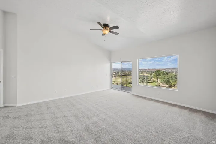 Spacious room with vaulted ceilings and light gray carpeting
