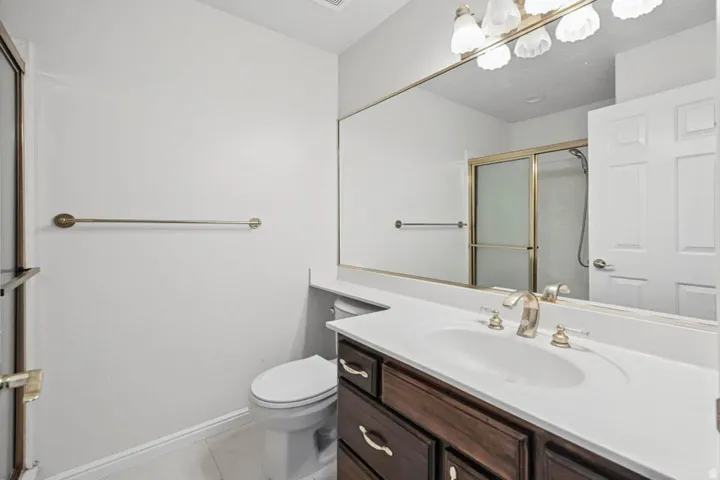 Integrated vanity with a single basin, dark wood-finish cabinetry, and a large wall-mounted mirror