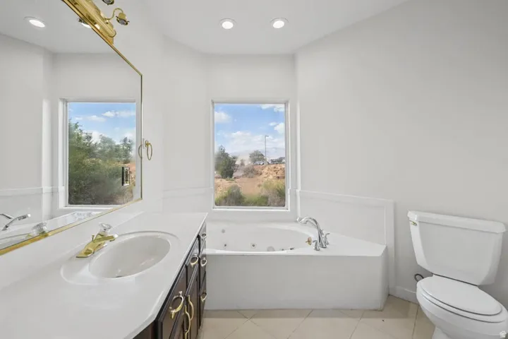 Vanity with integrated sink, gold-finish fixtures, and dark wood cabinetry
