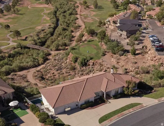 Tile roof residence with a paved driveway and an attached garage