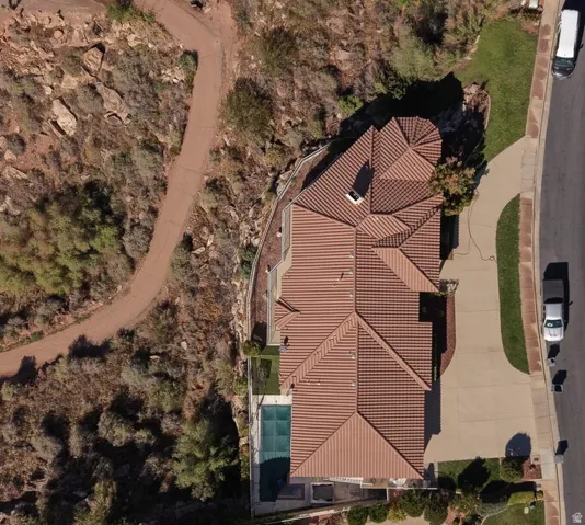 Tile roof residence with an expansive driveway, front lawn, and paved walkway