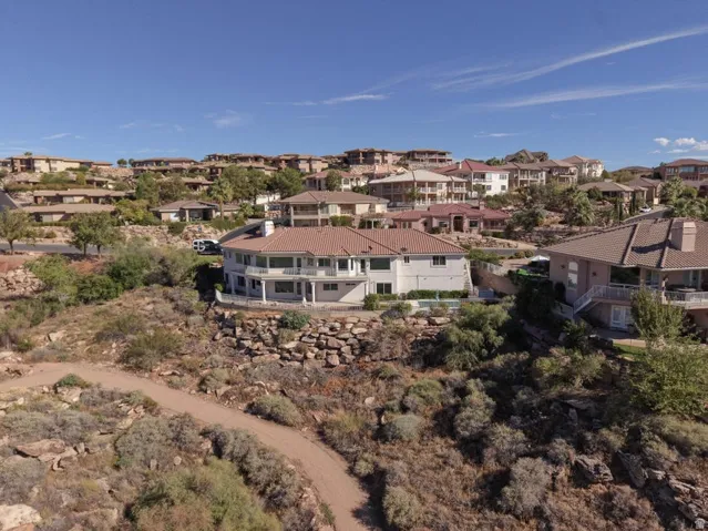 Terraced hillside residence featuring multiple balconies, a tiled roof, and an integrated swimming pool