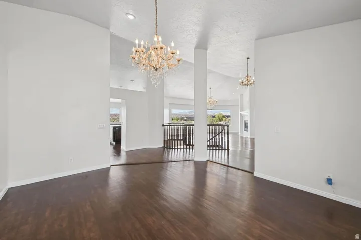 Wood-finish flooring throughout, vaulted ceiling, and decorative chandeliers