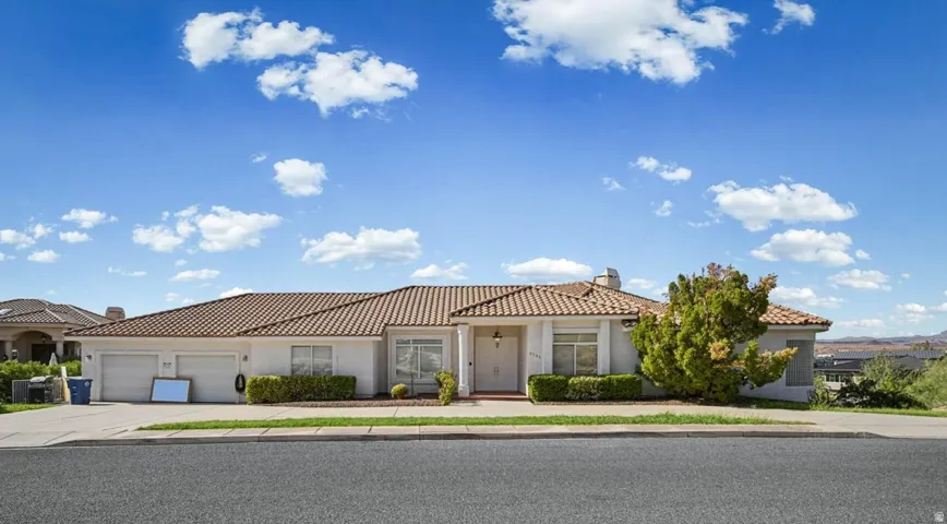 Single-story residence featuring a tile roof and light-colored stucco exterior