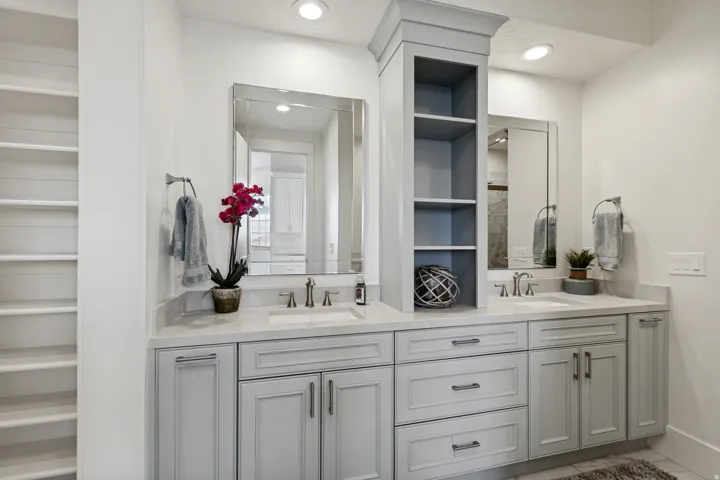 Dual vanity with undermount sinks, light-toned countertops, and gray cabinetry