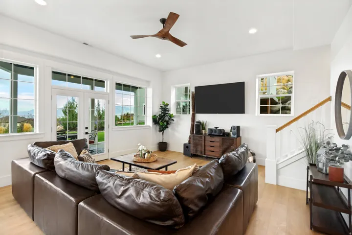 Bright living space featuring wood-finish flooring, a contemporary ceiling fan, and recessed lighting