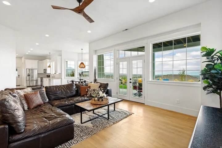 Open-concept living area featuring wood-finish flooring, a contemporary ceiling fan, and recessed lighting