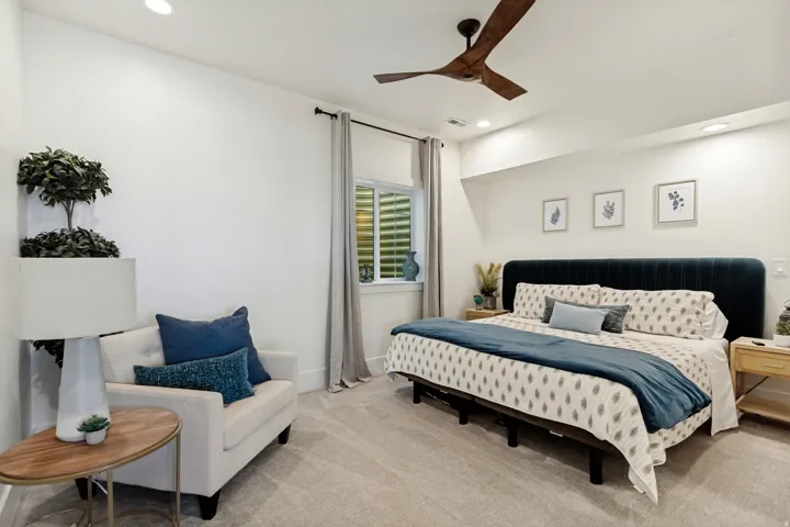 Recessed lighting, wood-finish ceiling fan, window with interior shutters, plush carpeting, built-in wall shelf