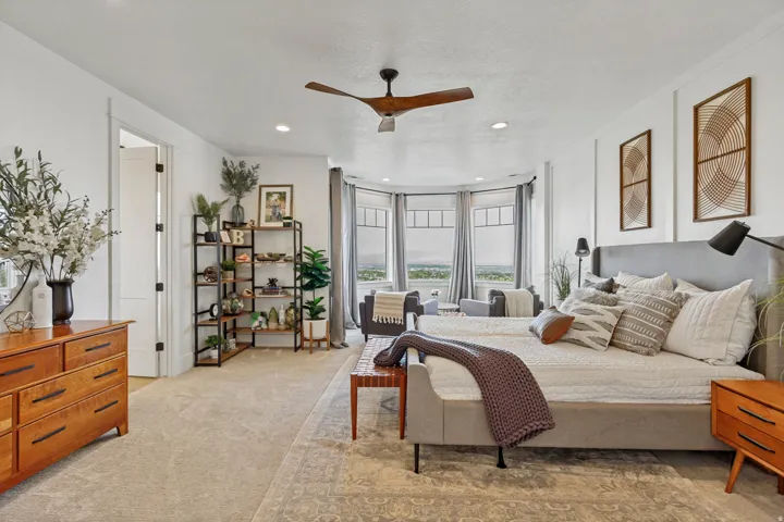 Spacious room with a bay window, recessed lighting, and a ceiling fan