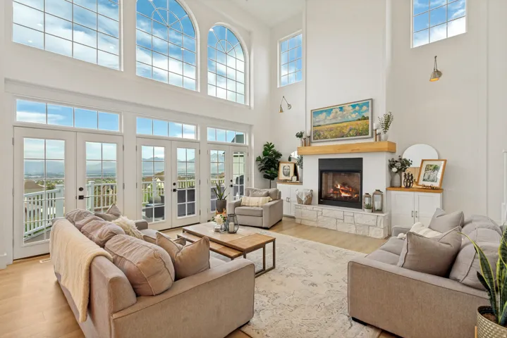 Double-height great room with expansive arched windows and light wood-finish flooring