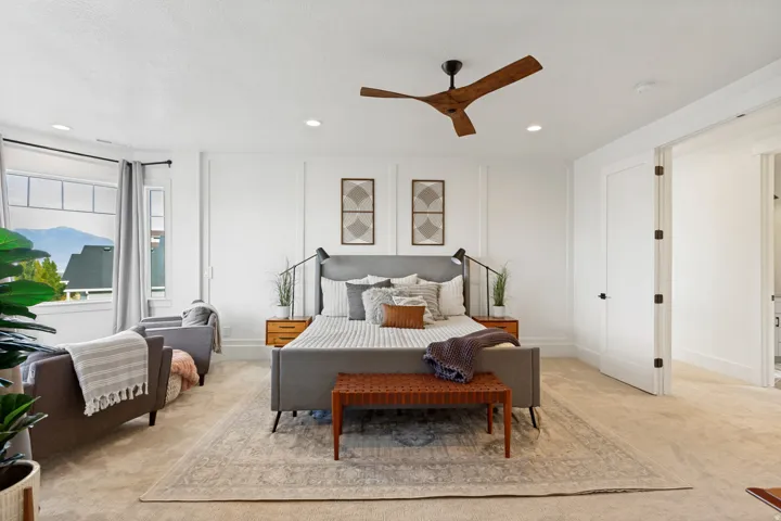 Recessed lighting, wood-finish ceiling fan, panel molding accent wall, large windows, and carpeted flooring
