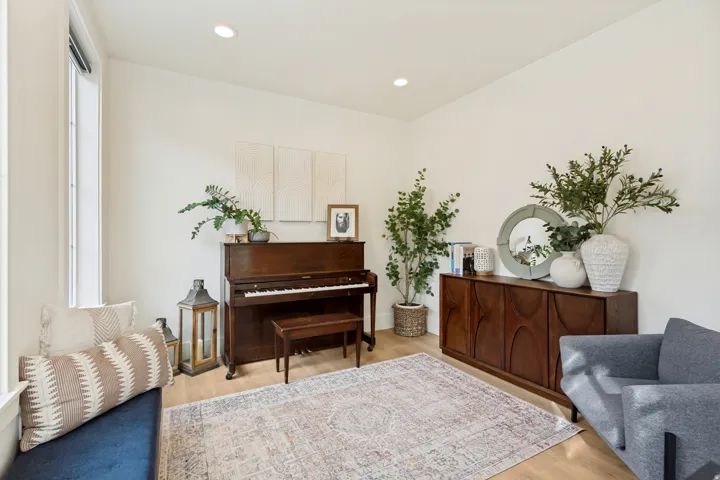 Recessed lighting, light wood-finish flooring, built-in window bench, and white wall finishes