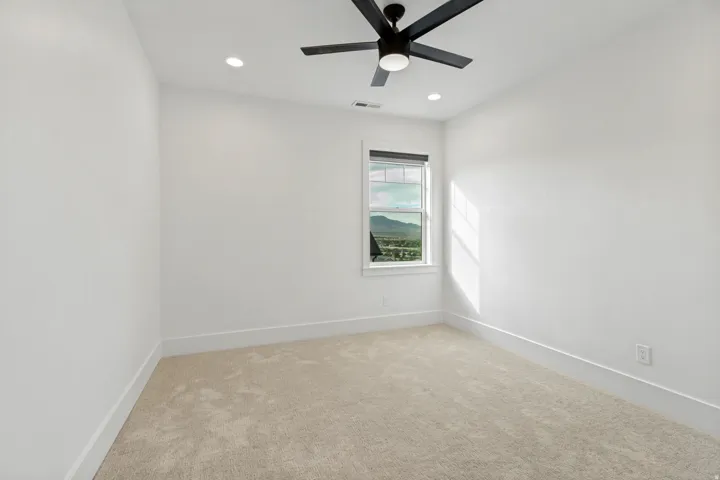 Neutral-toned carpeting, white walls, and recessed lighting