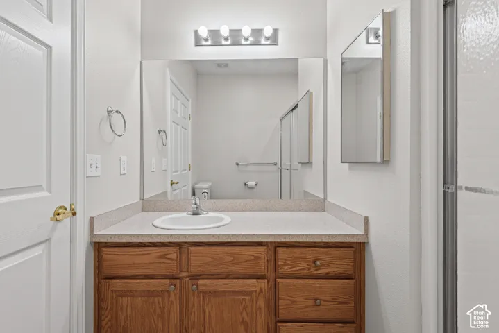 Vanity with a laminate countertop, integrated sink, and wood-finish cabinetry