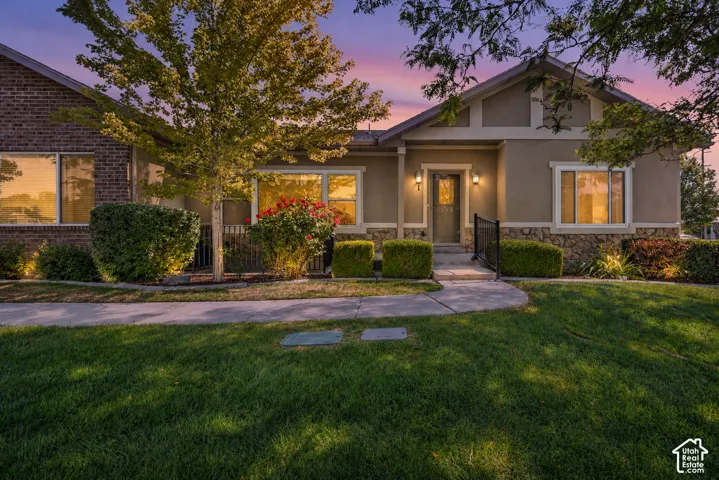 Single-story residence featuring a mixed-material exterior of brick and stucco, stone veneer accents, multi-pane windows, and a paved walkway