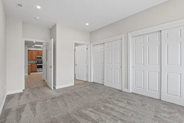 Recessed lighting, light gray wall paint, gray carpet flooring, white trim, and white paneled doors
