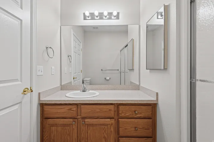 Vanity with a laminate countertop, integrated sink, and wood-finish cabinetry