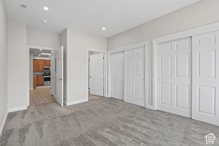 Recessed lighting, light gray wall paint, gray carpet flooring, white trim, and white paneled doors