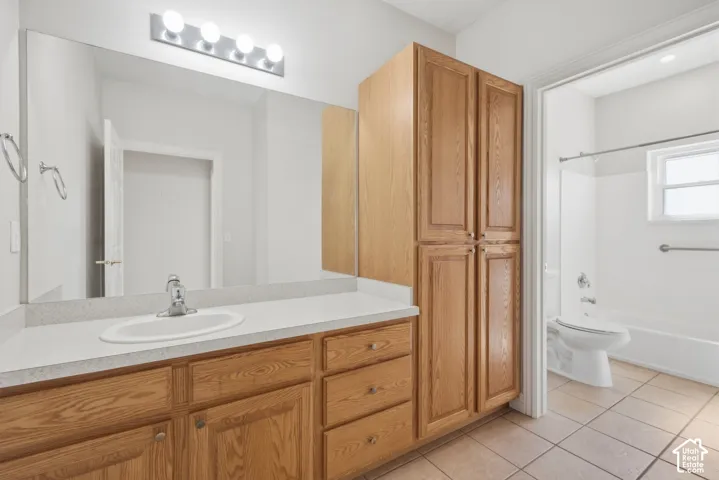 Bathroom featuring a vanity with an integrated sink, laminate countertop, and wood cabinetry