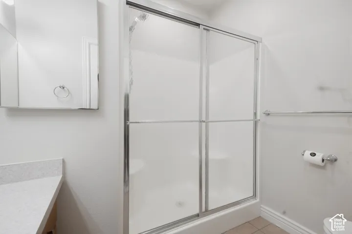 Shower with sliding frosted glass doors, a built-in shower seat, and a chrome towel bar