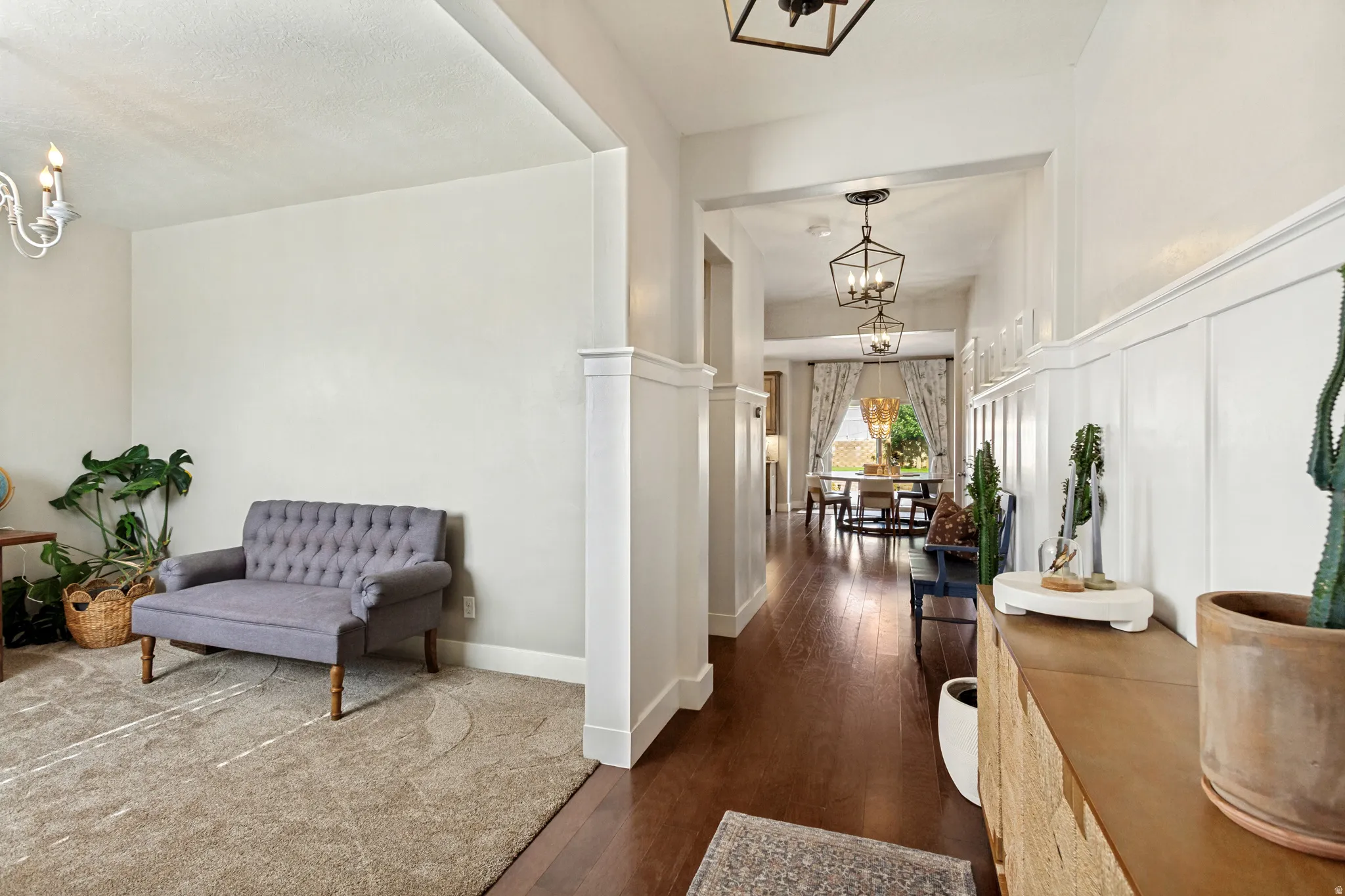 Hardwood flooring, recessed lighting, decorative ceiling light fixtures, wainscoting, and an arched entryway