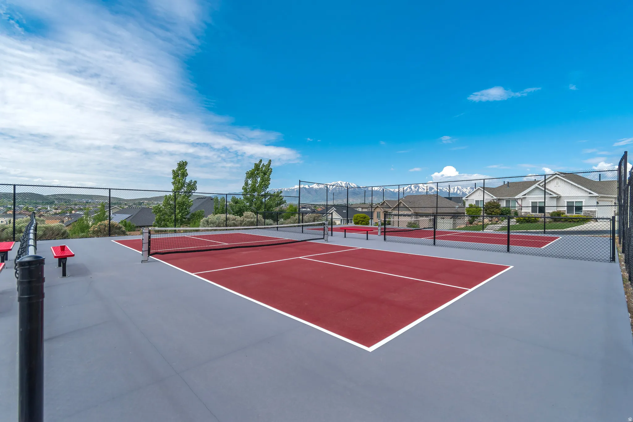 Red and gray sport court with black chain-link fencing