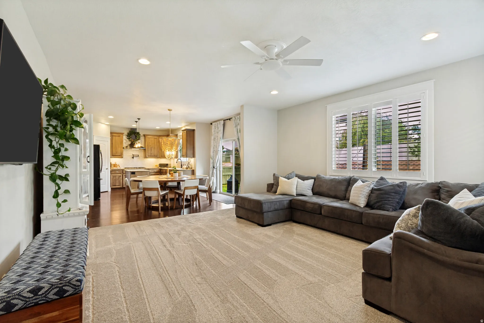 Recessed lighting, ceiling fan, plantation shutters, wood-finish flooring, and white built-in cabinetry