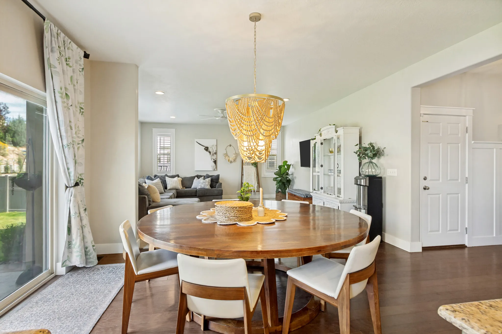 Open-concept dining area with wood-finish flooring, recessed lighting, and a sliding glass door