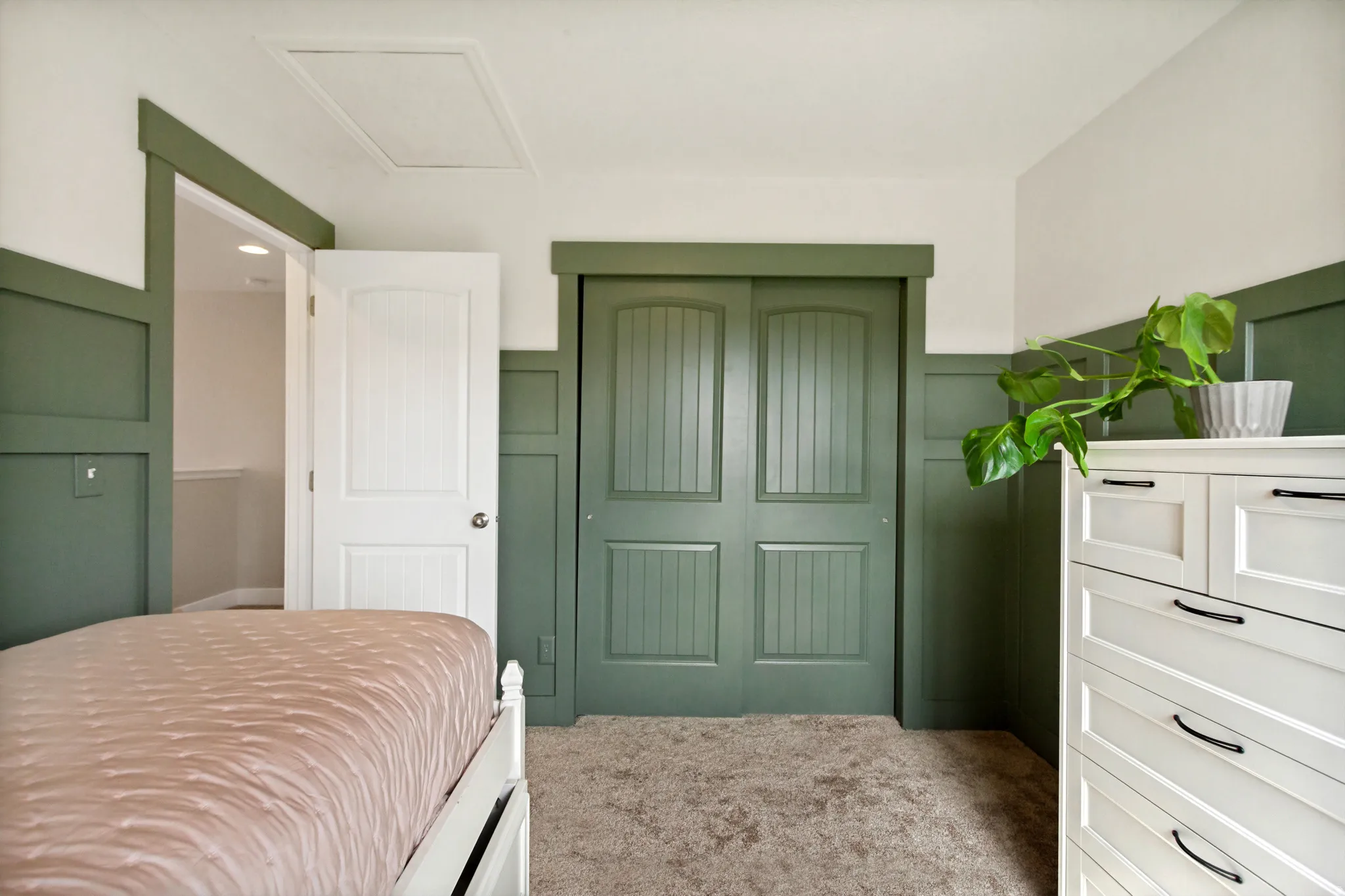 Carpeted flooring, paneled walls, white trim, solid paneled doors, and a built-in closet with sliding doors