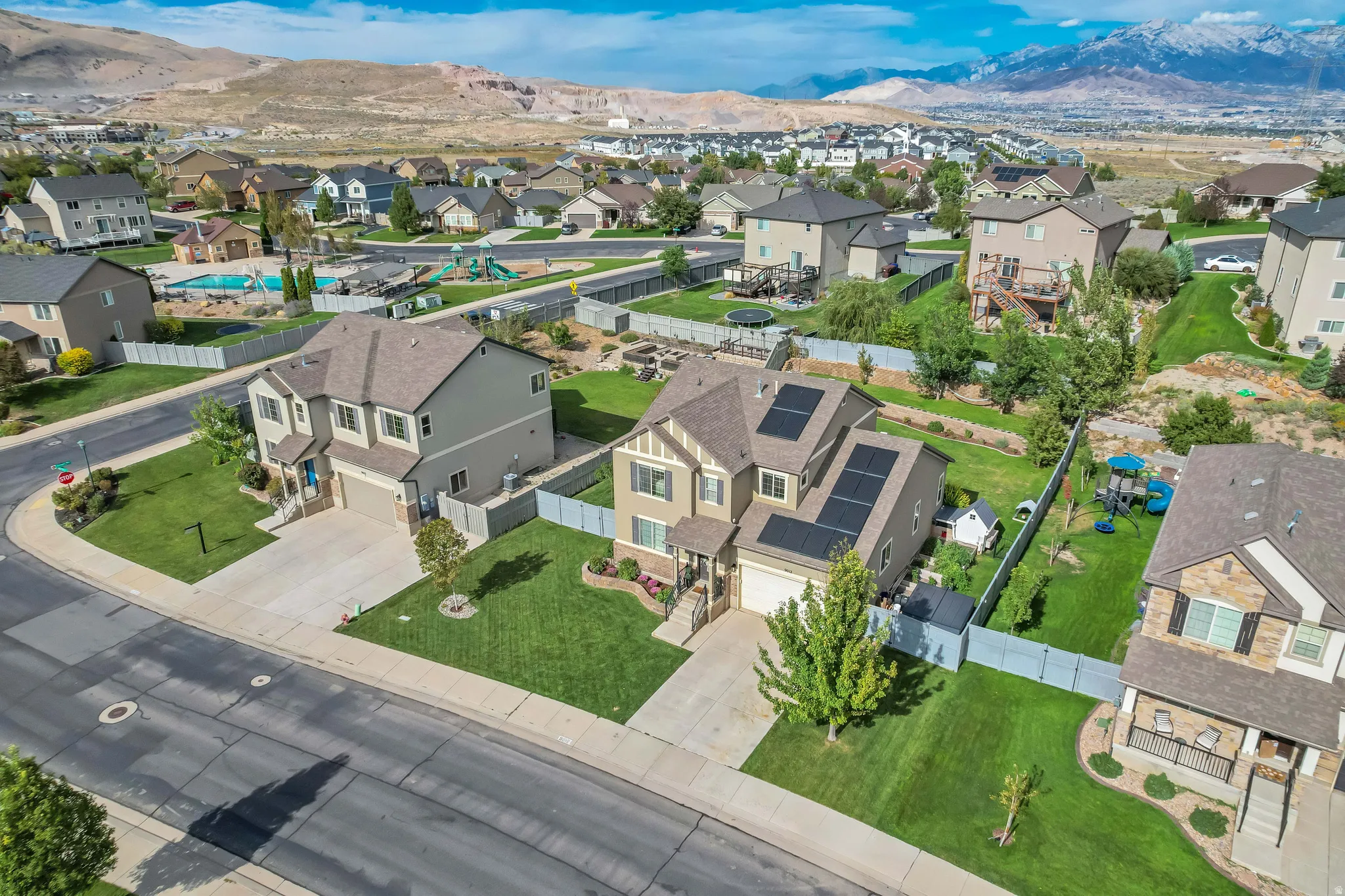 Two-story residence featuring a two-car garage, solar panels, and a landscaped front yard
