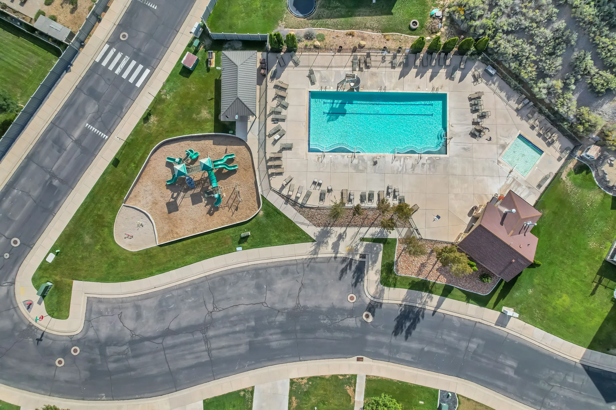 Community amenities featuring a large swimming pool, secondary smaller pool, adjacent playground, and a community building