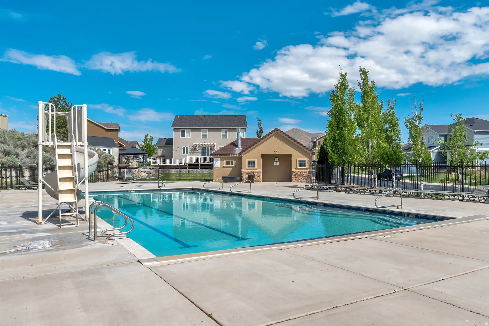 Expansive rectangular swimming pool with integrated steps, surrounded by a concrete deck
