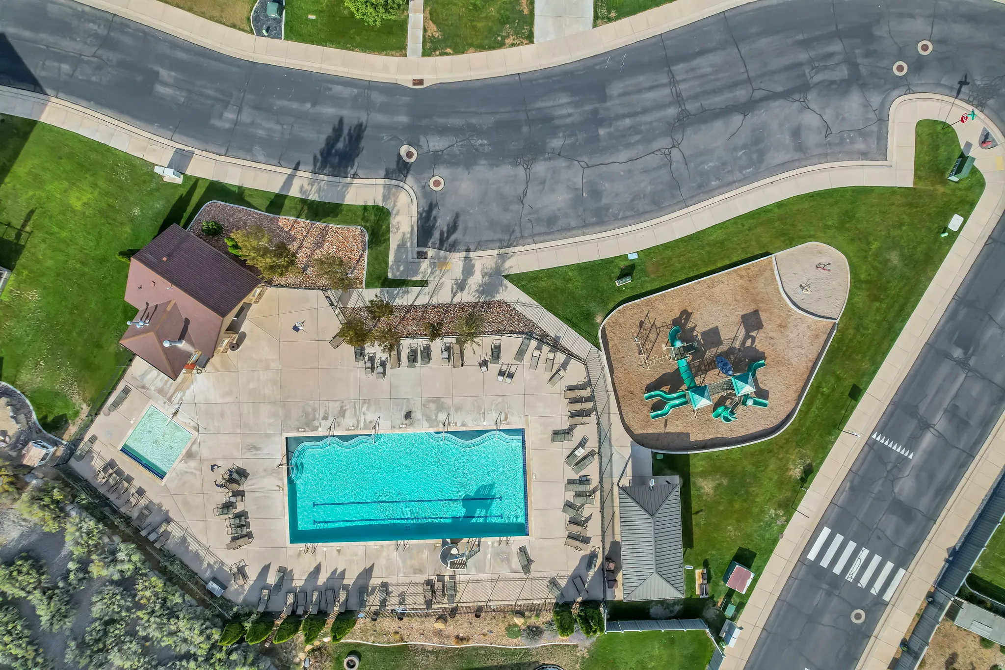 Community amenities featuring a swimming pool, separate wading pool, clubhouse structure, playground area, and manicured green spaces