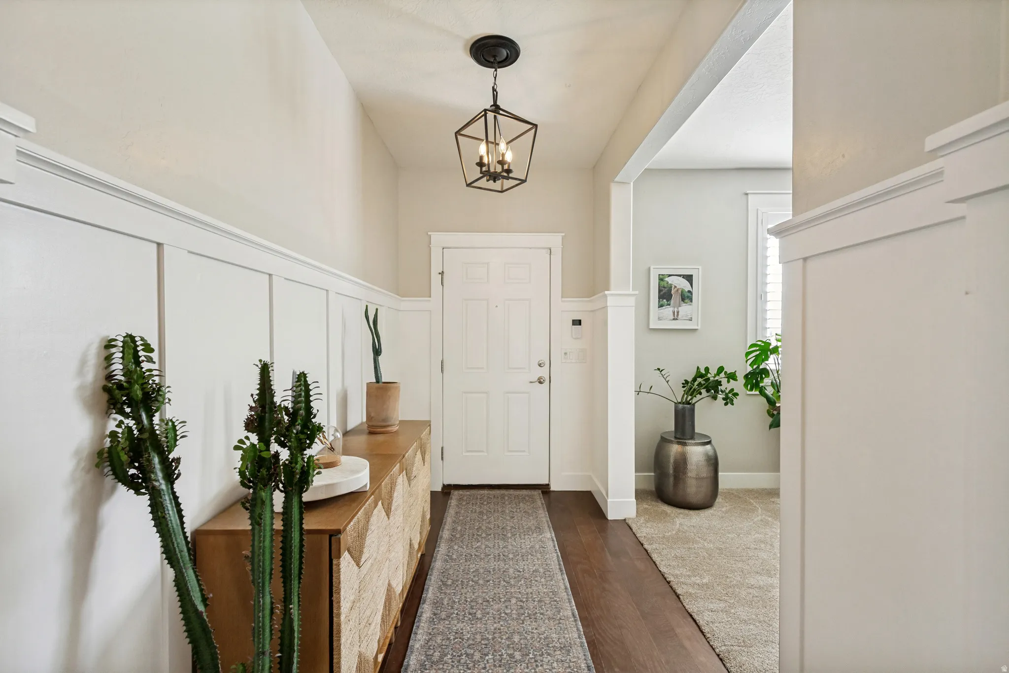Entryway featuring a vaulted ceiling and board and batten wainscoting